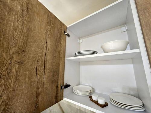 エレバンにあるYour Yerevan Homeの棚に白い皿やボウルが置かれたバスルーム