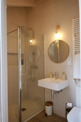 a bathroom with a shower and a sink and a mirror at El sueñu de Chari in Llanes