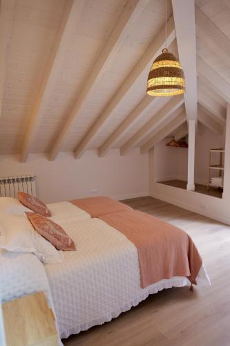 a bedroom with a large bed and a ceiling at El sueñu de Chari in Llanes