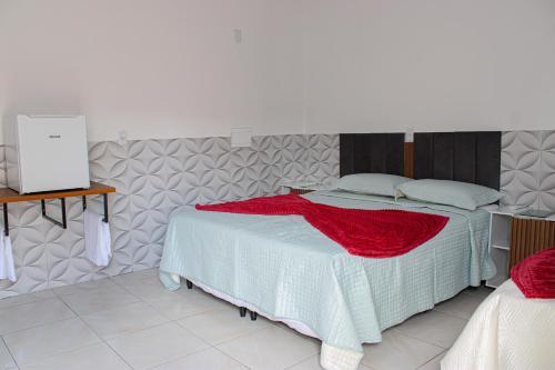 a bedroom with a bed with a red blanket at viladowalbinhobarreirinhas in Barreirinhas