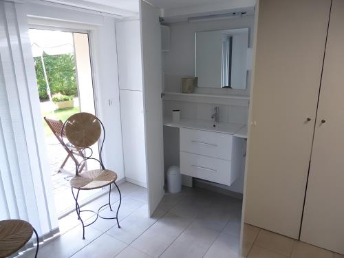 eine Küche mit einer Spüle sowie einem Tisch und Stühlen in der Unterkunft Gîte Les Platanes in Latresne