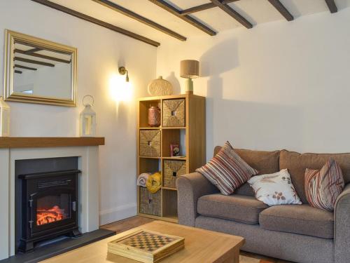 a living room with a couch and a fireplace at Stone Cottage in Wirksworth near Peak District in Wirksworth