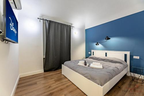 a bedroom with a bed with a blue wall at The Heart of Savona A - Cruise 2 min - AC - WiFi in Savona