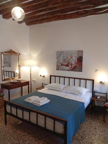a bedroom with a large bed with a blue blanket at Ενοικιαζόμενα Δωμάτια "ΜΕΡΣΙΝΗ" in Karistos