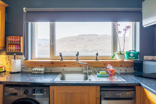a kitchen counter with a sink and a window at The Mountain Lake in Fort William