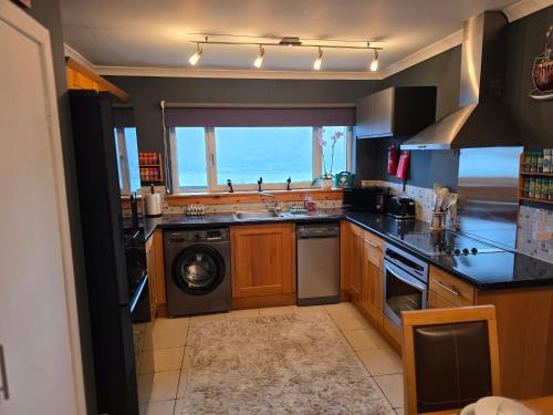 a kitchen with a sink and a washing machine at The Mountain Lake in Fort William