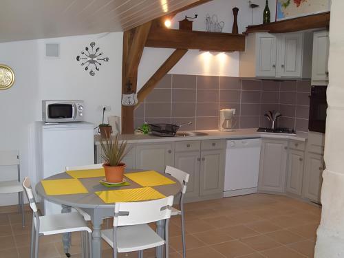 a kitchen with a table and a table and chairs at Gîte Mélany in Chargé
