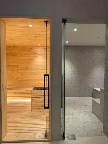 a glass door to a sauna in a room at Nuevo Studio en Edificio Qanvas- Piso 19 - Parque La Carolina in Quito