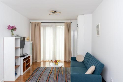 a living room with a blue couch and a table at Apart house EMA 2 in Bansko