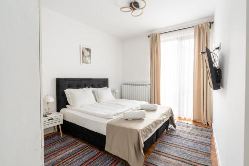 a white bedroom with a bed and a window at Apart house EMA 2 in Bansko