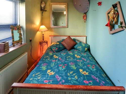 une petite chambre avec un lit avec une couette bleue dans l'établissement Dormy Cottage, à Skegness