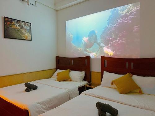 a room with two beds and a picture of a diver at Heart Of Hoan Kiem RARE 4BR large cozy private house center max 14pax in Hanoi