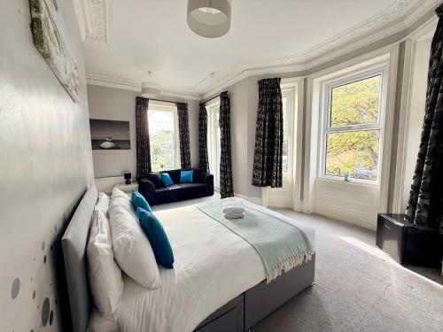a bedroom with a large bed with blue pillows at The Hedley Townhouse in Bournemouth
