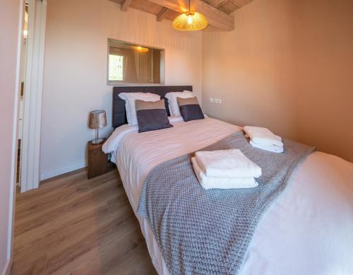 Un dormitorio con una cama grande con toallas. en Bergerie bien être, en Vaivre-et-Montoille