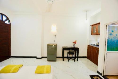 a kitchen with a refrigerator and a table in a room at White Horse in Hikkaduwa