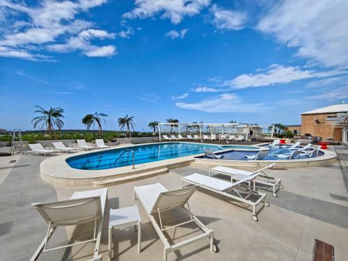 una piscina con tumbonas y una piscina en Hotel Gran Cacique Maiquetia, en Maiquetía
