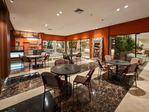 Un restaurante con mesas y sillas en una sala. en Hotel Gran Cacique Maiquetia, en Maiquetía