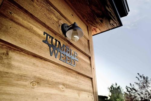 a sign on the side of a wooden building with a light at Escalante Escapes Tumble Weed- Bunk Escape in Escalante