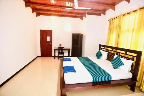 a bedroom with a bed with blue and white pillows at White Horse in Hikkaduwa