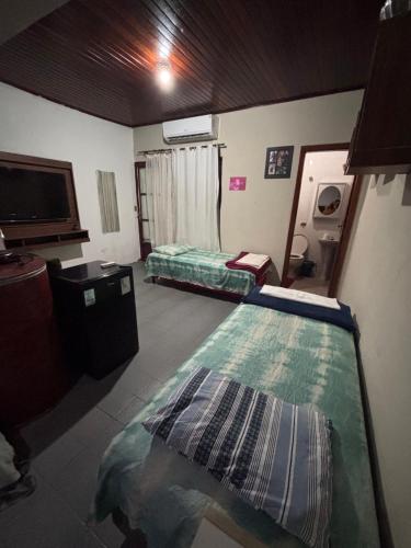 a room with two beds and a tv in it at Apto próx ao Shopping in Rondonópolis