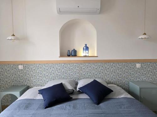 a bedroom with a bed with two blue pillows at L'évasion- Appartement cosy in Veuzain-sur-Loire