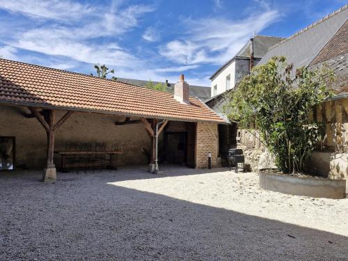 a courtyard of a building with a pavilion with a roof at L'évasion- Appartement cosy in Veuzain-sur-Loire