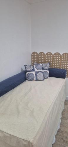 a bed with blue and white pillows on it at MA Prime Stay in Natal