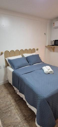 a bedroom with a bed with blue sheets and pillows at MA Prime Stay in Natal