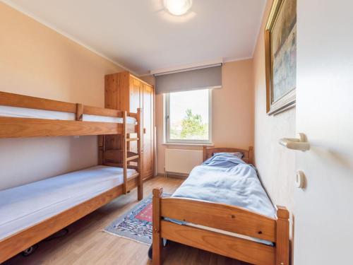 a bedroom with two bunk beds and a window at Aubépine premier in Sint-Idesbald