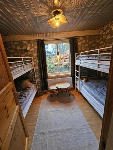 a room with three bunk beds and a table in it at Villa Blackberry, nära Kolmården & Norrköping in Åby