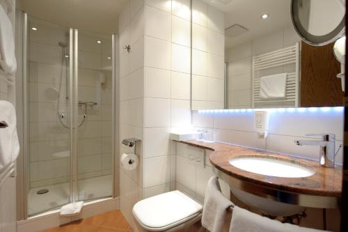a bathroom with a sink and a shower and a toilet at Hotel Nothnagel in Darmstadt