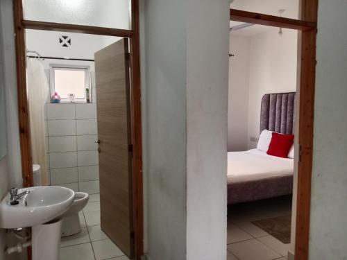 a bathroom with a sink and a bed in a room at Buxton Point Kandy Cozy Two Bedroom Apartment in Mombasa