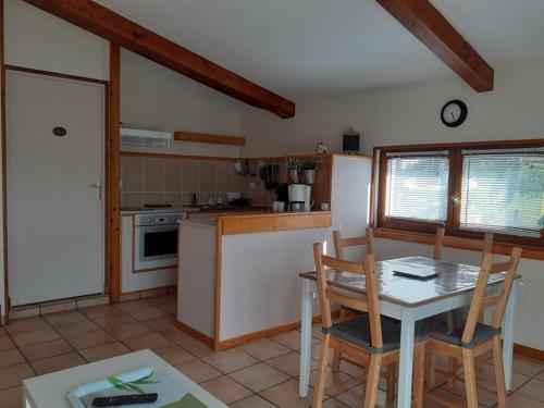 a kitchen with a table and chairs in a room at Gîte Pic de Cluzel in Saurier