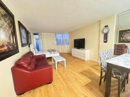 Spacious Apt Ocean Reserve Resort Amenities في صني آيلز بيتش: غرفة معيشة بها أريكة حمراء وتلفزيون