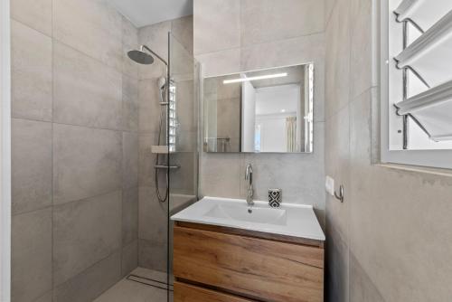 une salle de bain avec lavabo et douche dans l'établissement Blue Bay- Penthouse 4 persons Aquamarine, à Blue Bay