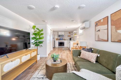a living room with a green couch and a table at Stay Portland - Vibrant Portland Getaway, Chic Flat in Portland