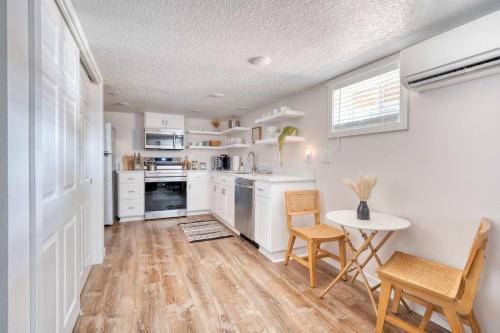 a kitchen with white cabinets and a table and chairs at Stay Portland - Vibrant Portland Getaway, Chic Flat in Portland