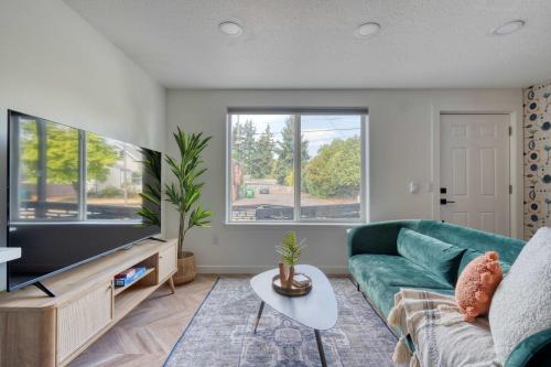 a living room with a green couch and a flat screen tv at Stay Portland - The Woodstock Inn - Reed College & Vintage Shops in Portland