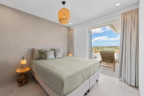 une chambre avec un lit et un balcon dans l'établissement Blue Bay- Penthouse 4 persons Aquamarine, à Blue Bay