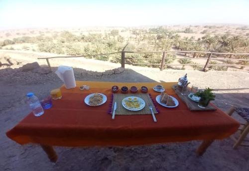 a table with plates of food on a red table at Auberge camping café restaurant Relax Tazoulait in Bou Dib