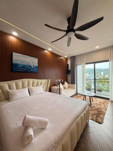 a bedroom with a large bed with a ceiling fan at JonHouse in Phu Quoc
