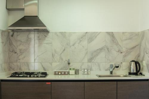 a kitchen with marble counter tops and a sink at Hostel Casa del Viajero 2 in El Calafate