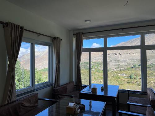 a room with a table and two large windows at Hotel the valley view in Muktināth