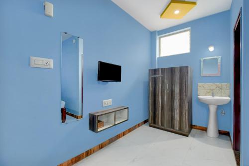 a blue bathroom with a sink and a toilet at Hotel O Redmoon Chikkamagaluru Railway Station in Chikmagalūr