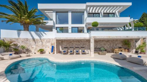 a villa with a swimming pool in front of a house at VACATION MARBELLA I Villa Riviera The View, Luxury Villa, Breathtaking Sea View, Private Pool, Close Distance to the Finest Beaches in Sitio de Calahonda