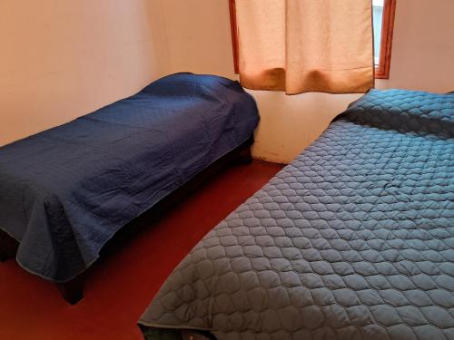 une chambre avec deux lits et une fenêtre dans l'établissement casa acogedora, à Melipeuco