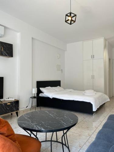 a bedroom with a large bed and a table at Laertis Apartments -By NOMA STAYS Cyprus in Paphos