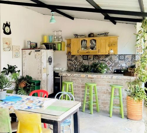 a kitchen with a table and green stools at Betania Alojamiento Rural Quindío Eje Cafetero espectacular! in Circasia