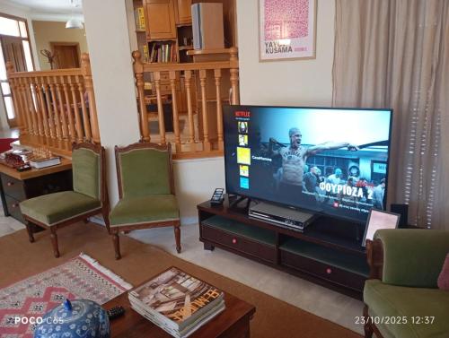 a living room with a flat screen tv and chairs at CasaMamma in Drama
