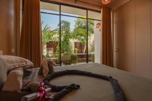 a bedroom with a bed with a stuffed animal on it at Ahola Thoddoo, Maldives in Thoddoo